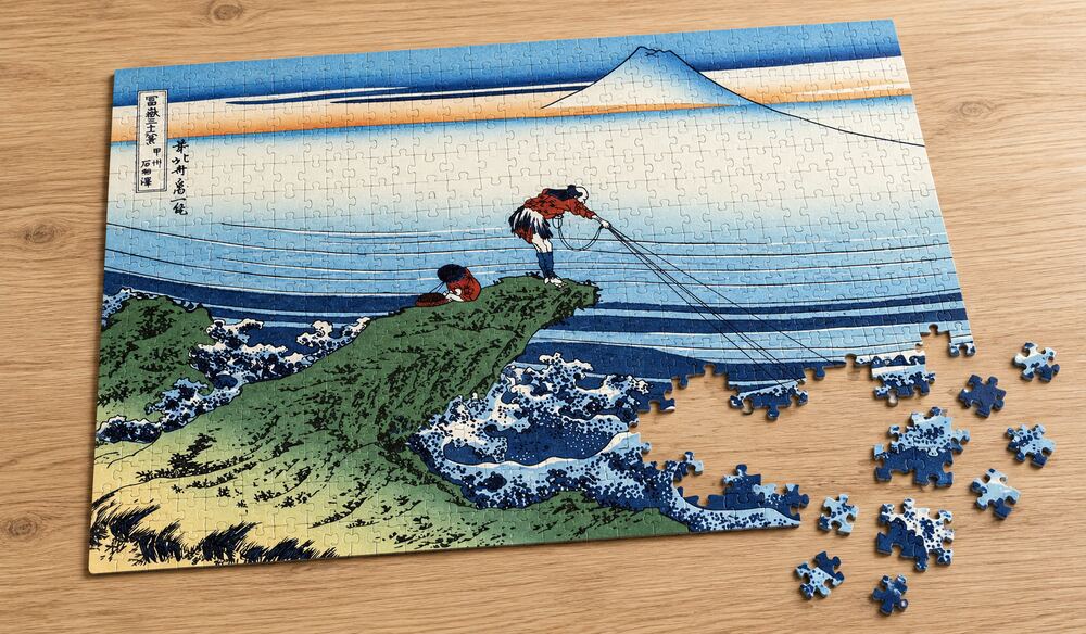 葛飾北斎「富嶽三十六景 甲州石班沢」の組み立て途中のジグソーパズルを卓上に置いたイメージ