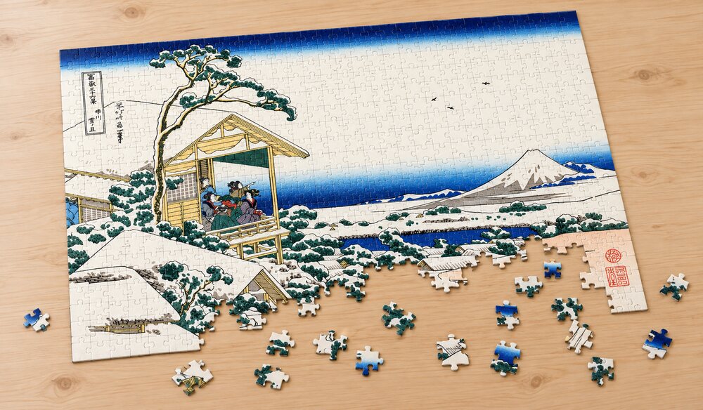 葛飾北斎「富嶽三十六景 礫川雪ノ旦」の組み立て途中のジグソーパズルを卓上に置いたイメージ