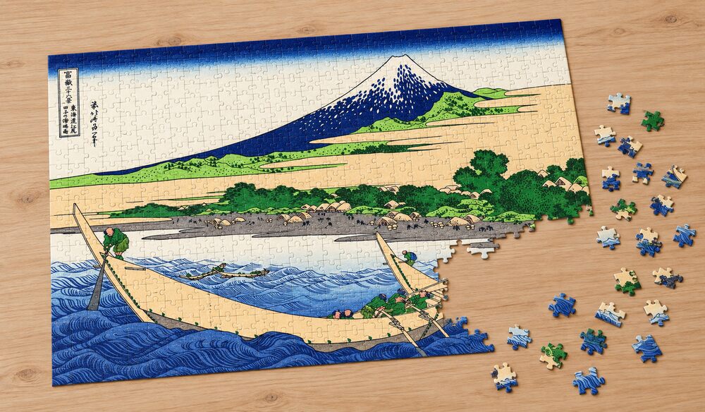 葛飾北斎「富嶽三十六景 東海道江尻田子の浦略図」の組み立て途中のジグソーパズルを卓上に置いたイメージ