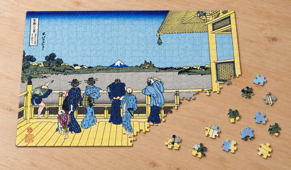 葛飾北斎「富嶽三十六景 五百らかん寺さざゐどう」の組み立て途中のジグソーパズルを卓上に置いたイメージ