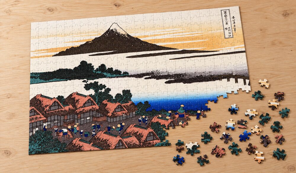 葛飾北斎「富嶽三十六景 甲州伊沢暁」の組み立て途中のジグソーパズルを卓上に置いたイメージ