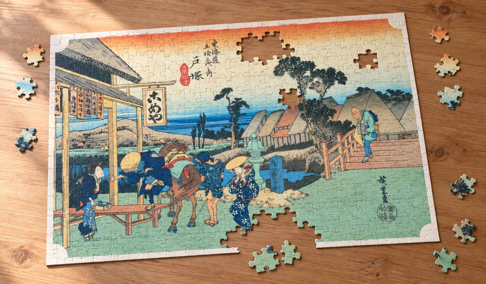 歌川広重「東海道五十三次 戸塚宿 元町別道」を絵柄にした、組み立て途中のジグソーパズルのイメージ