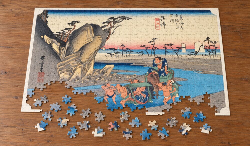 歌川広重「東海道五十三次 興津宿 興津川」を絵柄にした、組み立て途中のジグソーパズルのイメージ