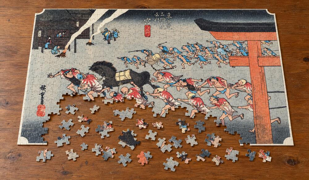 歌川広重「東海道五十三次 宮宿 熱田神事」を絵柄にした、組み立て途中のジグソーパズルのイメージ