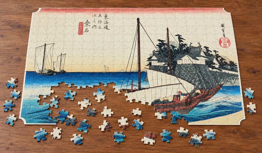 歌川広重「東海道五十三次 桑名宿 七里渡口」を絵柄にした、組み立て途中のジグソーパズルのイメージ