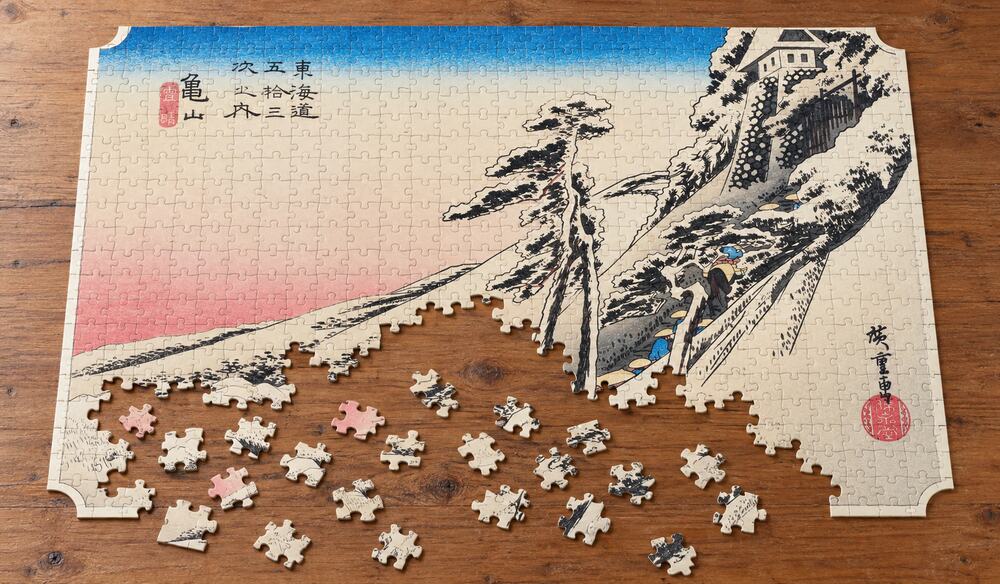 歌川広重「東海道五十三次 亀山宿 雪晴」を絵柄にした、組み立て途中のジグソーパズルのイメージ