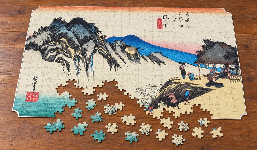 歌川広重「東海道五十三次 阪之下宿 筆捨嶺」を絵柄にした、組み立て途中のジグソーパズルのイメージ