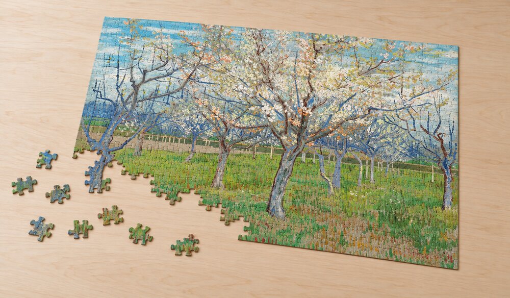 ゴッホ「ピンクの果樹園」の組み立て途中を表したアートパズルのイメージ。淡いピンクや白の花と大きな木の枝ぶりを手がかりに楽しむ場面