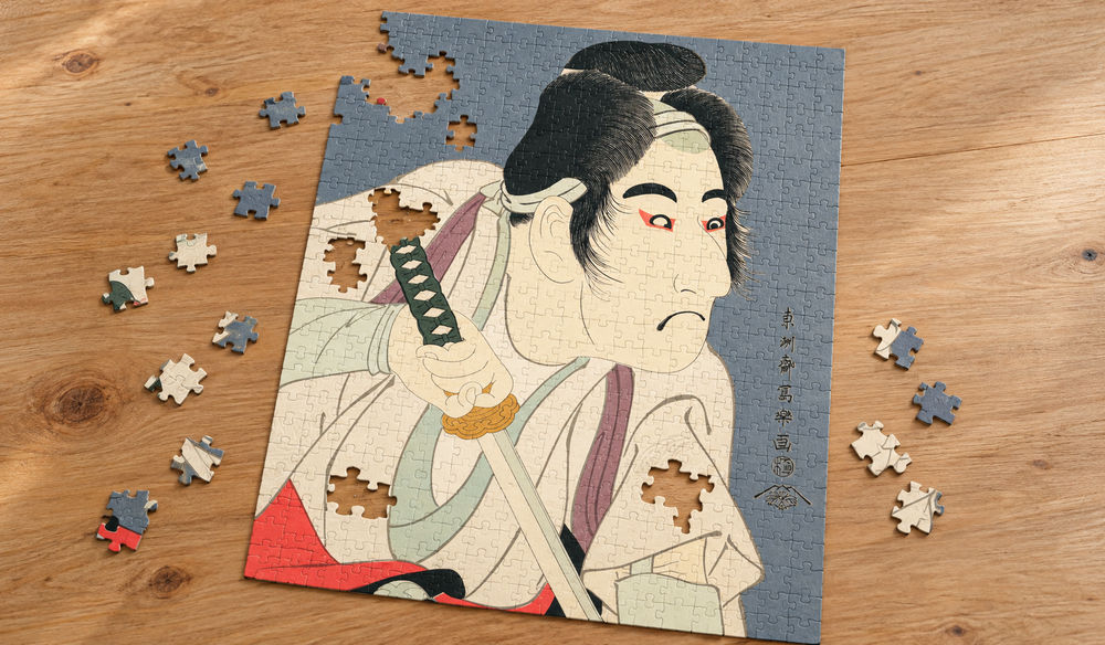 東洲斎写楽「二世坂東三津五郎の石井源蔵」を絵柄にした、組み立て途中のジグソーパズルのイメージ