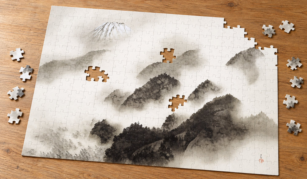 横山大観「雨霽る」を絵柄にした、組み立て途中のジグソーパズルのイメージ