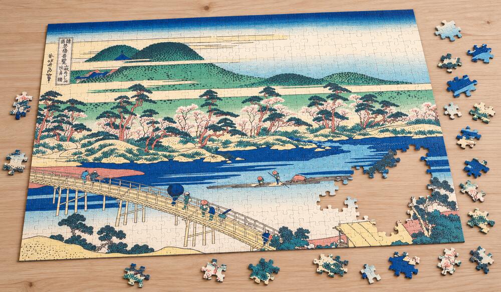 葛飾北斎「諸国名橋奇覧 山城あらし山 吐月橋」を絵柄にした、組み立て途中のジグソーパズルのイメージ