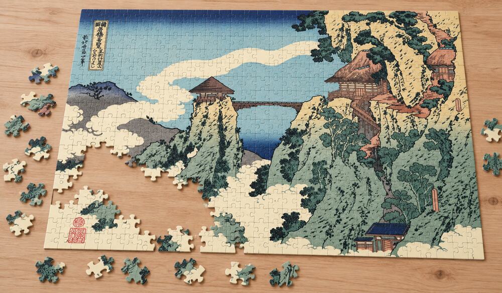 葛飾北斎「諸国名橋奇覧 足利行道山 くものかけはし」を絵柄にした、組み立て途中のジグソーパズルのイメージ