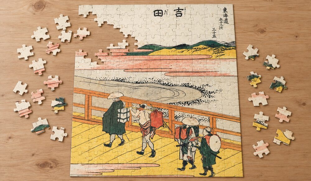 葛飾北斎「東海道五十三次 吉田」を絵柄にした、組み立て途中のジグソーパズルのイメージ