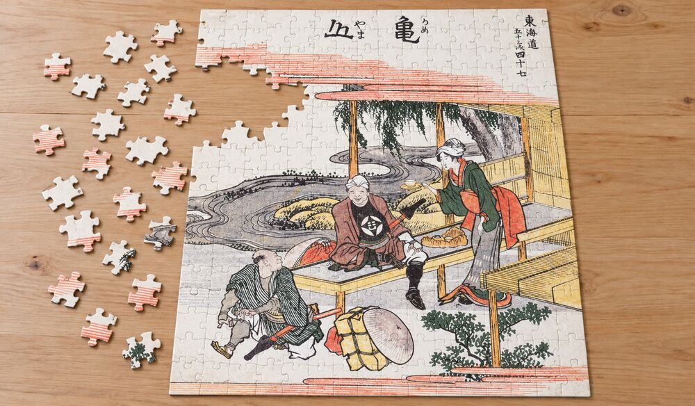 葛飾北斎「東海道五十三次 亀山」を絵柄にした、組み立て途中のジグソーパズルのイメージ
