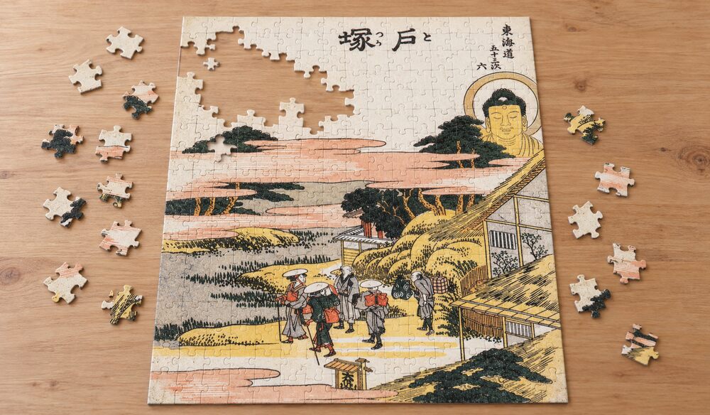 葛飾北斎「東海道五十三次 戸塚」を絵柄にした、組み立て途中のジグソーパズルのイメージ