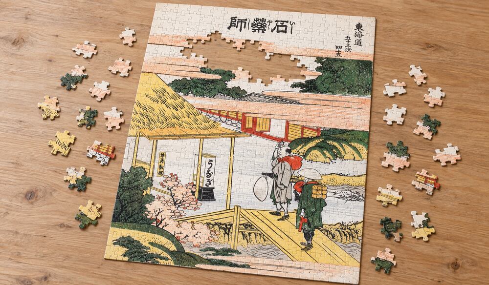 葛飾北斎「東海道五十三次 石薬師」を絵柄にした、組み立て途中のジグソーパズルのイメージ
