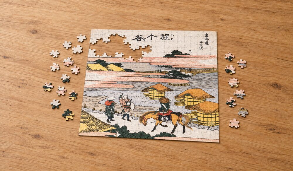 葛飾北斎「東海道五十三次 程ヶ谷」を絵柄にした、組み立て途中のジグソーパズルのイメージ