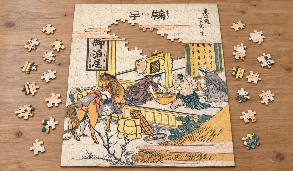 葛飾北斎「東海道五十三次 鞠子」を絵柄にした、組み立て途中のジグソーパズルのイメージ