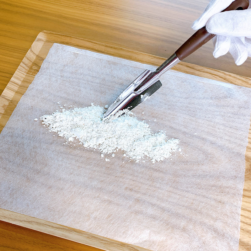 パウダー状のご遺骨を水溶性用紙の上に敷き詰め