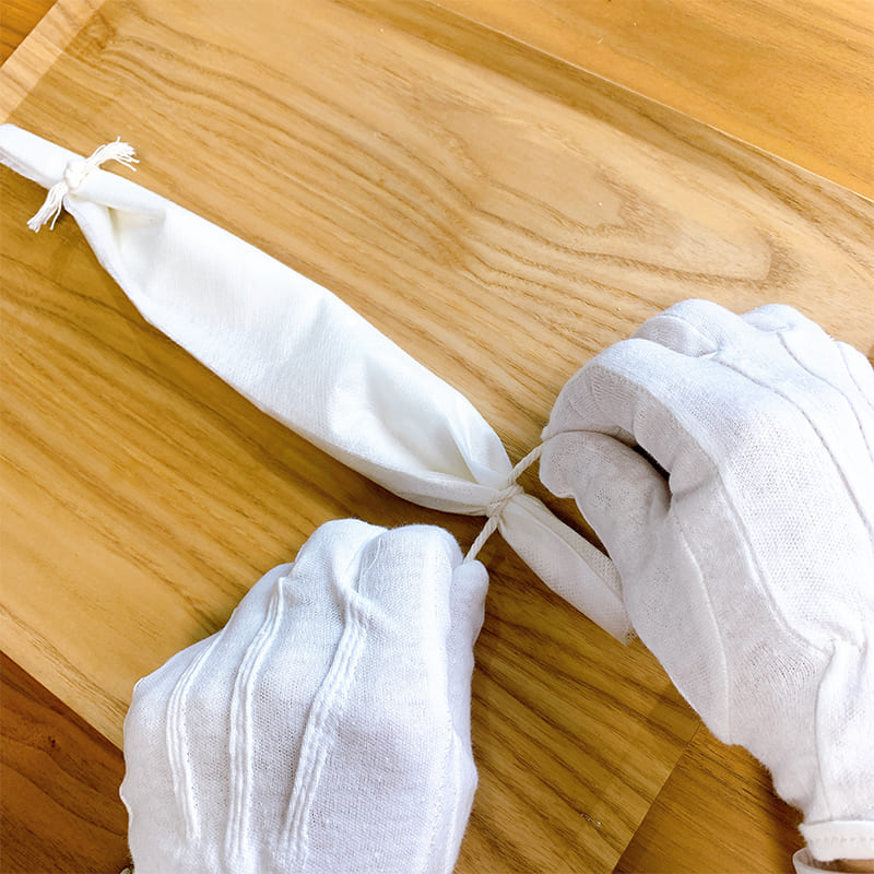 包んだ用紙の端を自然素材の紐で結ぶ